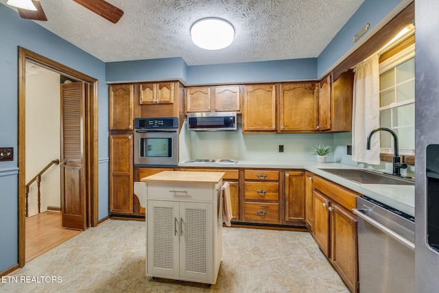 5122 Moody Dr, Kingsport, TN 37664 - kitchen featuring stainless steel appliances, brown cabinetry, light flooring, a textured ceiling, and a ceiling fan