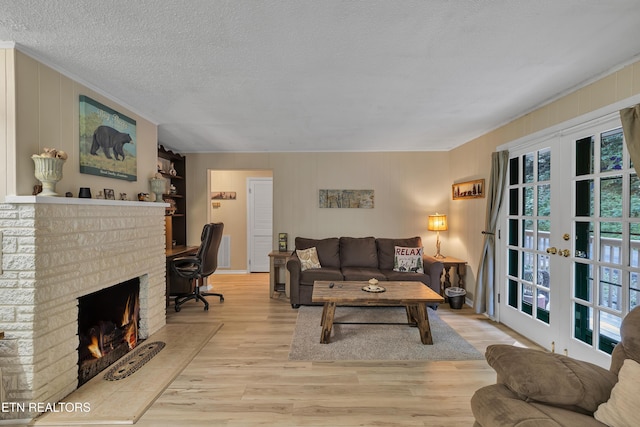 305 Shields View Dr, Gatlinburg, TN 37738 - living room featuring wood finished floors, french doors, crown molding, a textured ceiling, and a fireplace