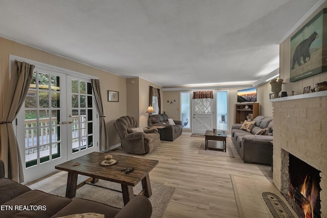 305 Shields View Dr, Gatlinburg, TN 37738 - living room with a brick fireplace, plenty of natural light, light wood-type flooring, french doors, and crown molding