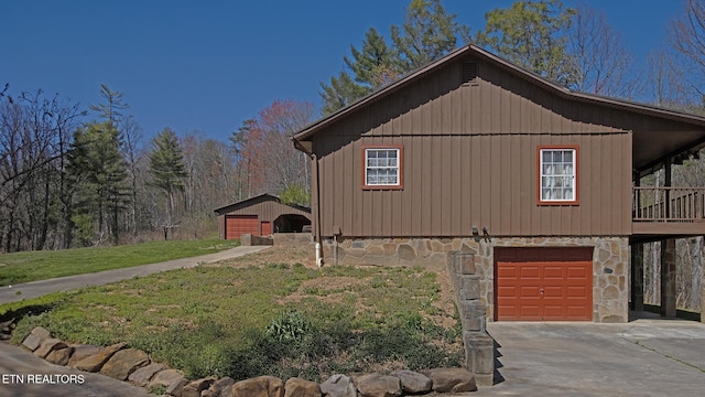 805 Punkton Rd, Del Rio, TN 37727 - view of side of home featuring a garage, stone siding, concrete driveway, board and batten siding, and a lawn