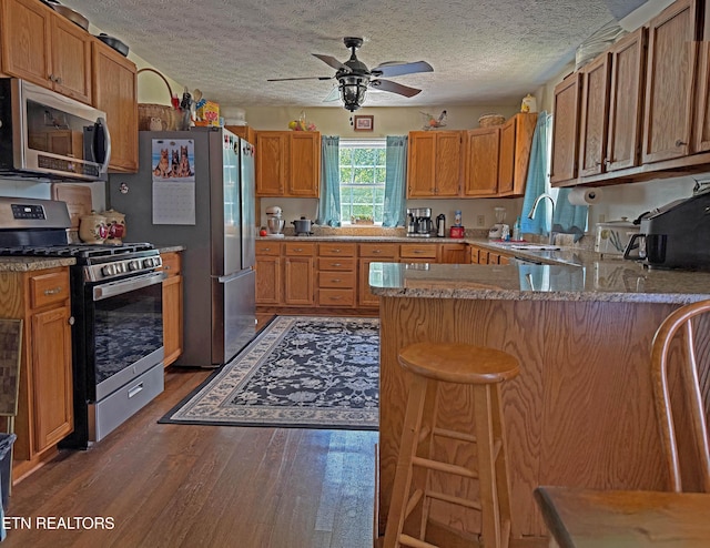 805 Punkton Rd, Del Rio, TN 37727 - kitchen featuring appliances with stainless steel finishes, a peninsula, wood finished floors, ceiling fan, and a textured ceiling