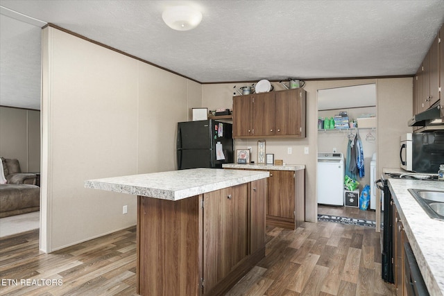 90 Byers Ln, Crossville, TN 38571 - kitchen featuring freestanding refrigerator, washer / dryer, wood finished floors, light countertops, and a textured ceiling