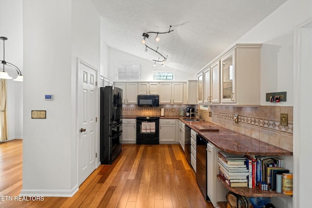 1476 Pheasants Glen Dr, Knoxville, TN 37923 - kitchen featuring black appliances, vaulted ceiling, tasteful backsplash, light wood finished floors, and a textured ceiling