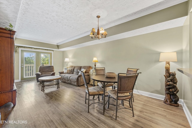 818 Golf View Blvd Unit 1502, Pigeon Forge, TN 37863 - dining room featuring crown molding, light wood-style flooring, a textured ceiling, and a chandelier