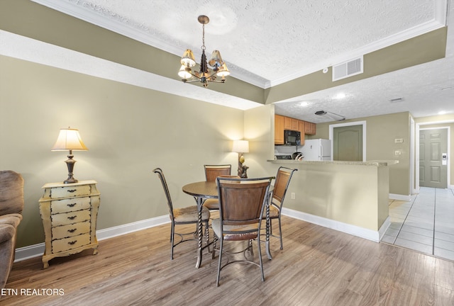 818 Golf View Blvd Unit 1502, Pigeon Forge, TN 37863 - dining room with a textured ceiling, light wood finished floors, a chandelier, and ornamental molding