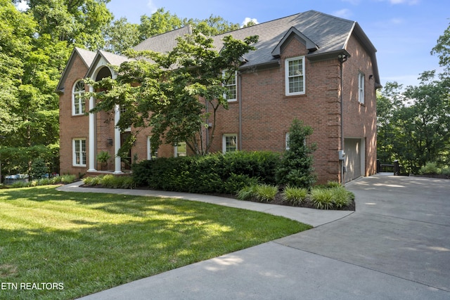 11424 Gates Mill Dr, Knoxville, TN 37934 - view of front facade featuring driveway, brick siding, a front yard, and an attached garage