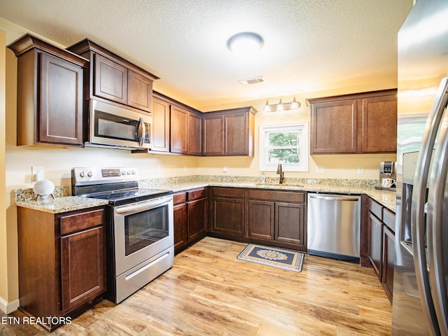 4139 Browder Hollow Rd, Lenoir City, TN 37771 - kitchen with appliances with stainless steel finishes, light wood-type flooring, light stone counters, and a textured ceiling
