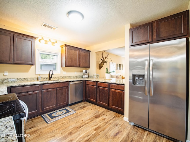 4139 Browder Hollow Rd, Lenoir City, TN 37771 - kitchen featuring stainless steel appliances, light wood-style flooring, dark brown cabinets, light stone counters, and a textured ceiling