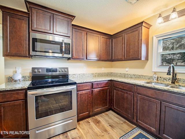 4139 Browder Hollow Rd, Lenoir City, TN 37771 - kitchen featuring appliances with stainless steel finishes, light wood finished floors, and light stone counters