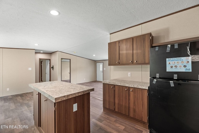 308 Cowan Ln, Lafollette, TN 37766 - kitchen featuring freestanding refrigerator, a textured ceiling, dark wood-style flooring, light countertops, and a kitchen island