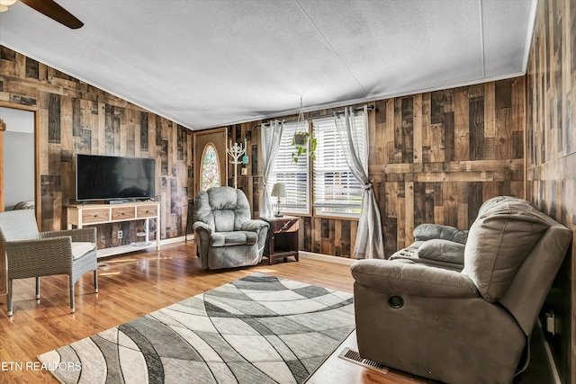 125 Loggers Ln, Clinton, TN 37716 - living area with wooden walls, wood finished floors, vaulted ceiling, ceiling fan, and a textured ceiling