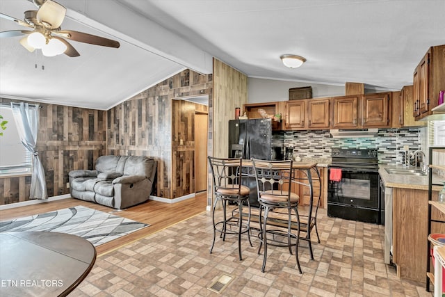125 Loggers Ln, Clinton, TN 37716 - kitchen featuring range with electric stovetop, black fridge, wooden walls, light countertops, and ceiling fan