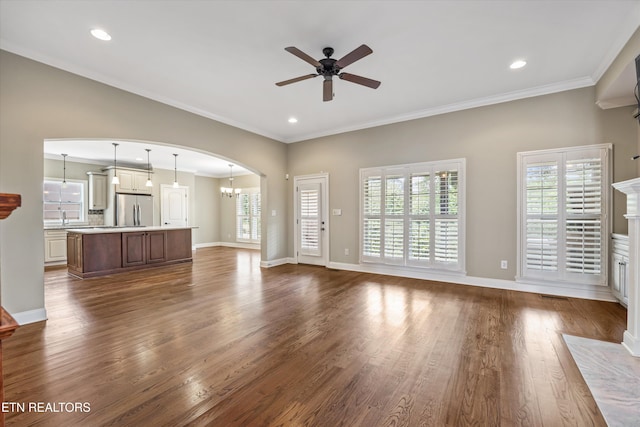 1219 Barton Place Ln, Knoxville, TN 37922 - unfurnished living room featuring ceiling fan, arched walkways, dark wood-type flooring, crown molding, and a chandelier