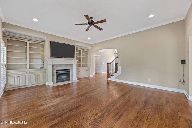 1219 Barton Place Ln, Knoxville, TN 37922 - unfurnished living room featuring arched walkways, a ceiling fan, ornamental molding, a tile fireplace, and wood finished floors