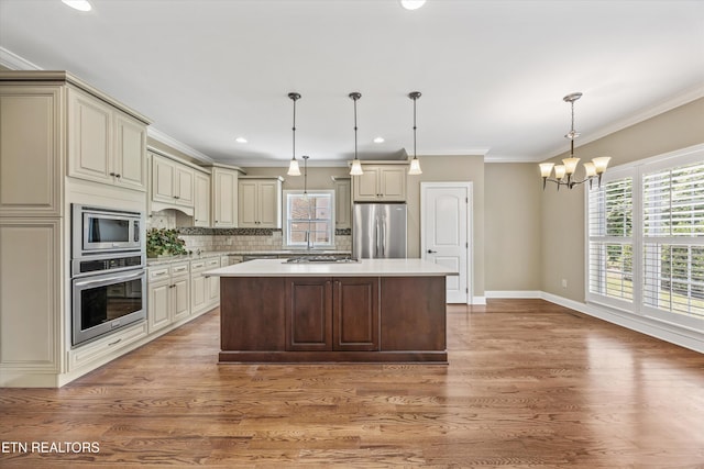 1219 Barton Place Ln, Knoxville, TN 37922 - kitchen with appliances with stainless steel finishes, cream cabinetry, a chandelier, healthy amount of natural light, and crown molding