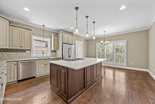 1219 Barton Place Ln, Knoxville, TN 37922 - kitchen with stainless steel appliances, cream cabinetry, a chandelier, tasteful backsplash, and crown molding