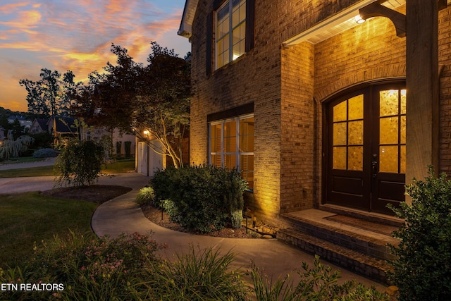 1219 Barton Place Ln, Knoxville, TN 37922 - exterior entry at dusk featuring french doors and brick siding