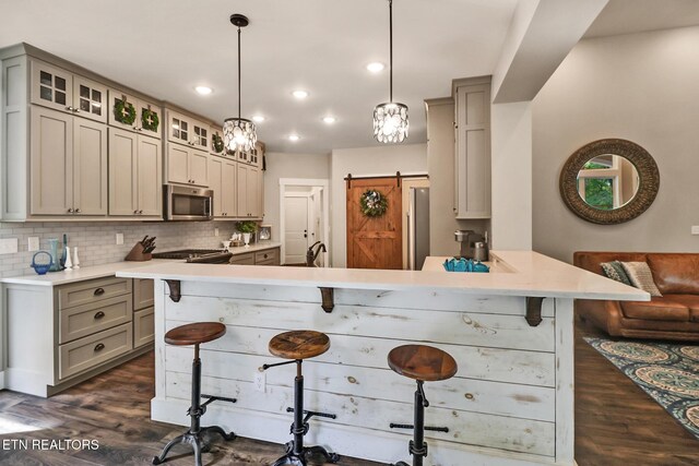 265 Falling Leaf Rd, Jamestown, TN 38556 - kitchen with stainless steel microwave, gray cabinets, a kitchen breakfast bar, a peninsula, and tasteful backsplash