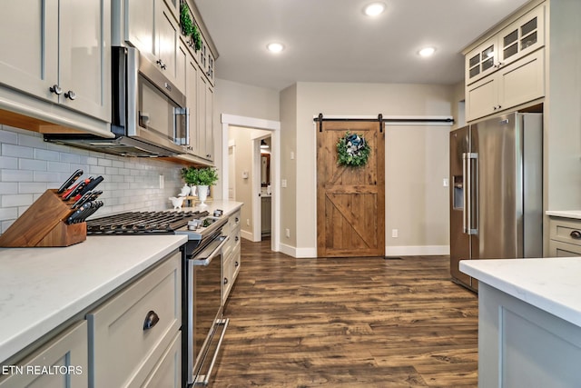265 Falling Leaf Rd, Jamestown, TN 38556 - kitchen with stainless steel appliances, a barn door, light countertops, backsplash, and dark wood-type flooring