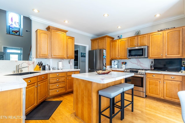 1155 Evelyn Mae Way, Knoxville, TN 37923 - kitchen with stainless steel appliances, a kitchen bar, ornamental molding, light wood-style flooring, and a center island