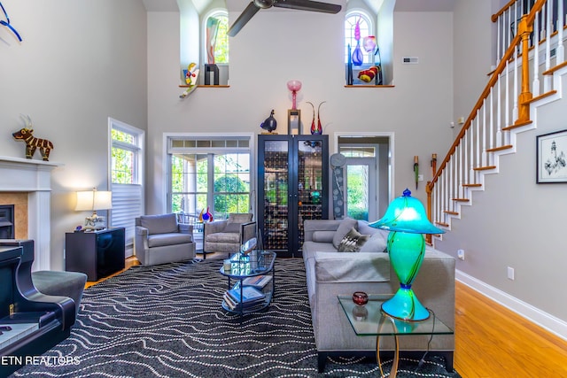 1155 Evelyn Mae Way, Knoxville, TN 37923 - living room featuring wood finished floors, a towering ceiling, ceiling fan, a fireplace, and stairway