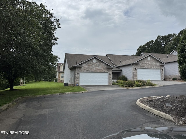 101 Pear Tree Ln, Loudon, TN 37774 - view of front of home with stone siding, a garage, a front lawn, and asphalt driveway
