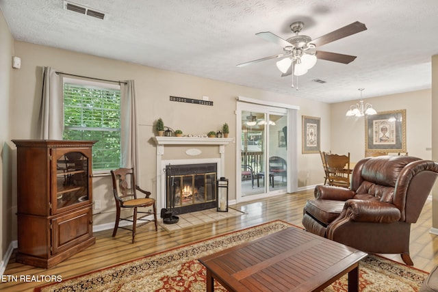 8600 Olde Colony Trl Unit 106, Knoxville, TN 37923 - living area with a ceiling fan, a fireplace with flush hearth, light wood-style floors, a textured ceiling, and a chandelier