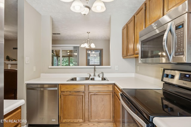 8600 Olde Colony Trl Unit 106, Knoxville, TN 37923 - kitchen featuring stainless steel appliances, a chandelier, a textured ceiling, and light countertops