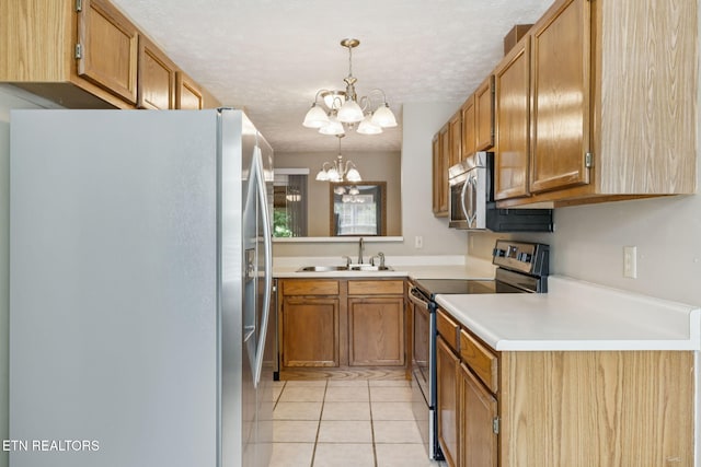 8600 Olde Colony Trl Unit 106, Knoxville, TN 37923 - kitchen with stainless steel appliances, a chandelier, light tile patterned flooring, light countertops, and hanging light fixtures