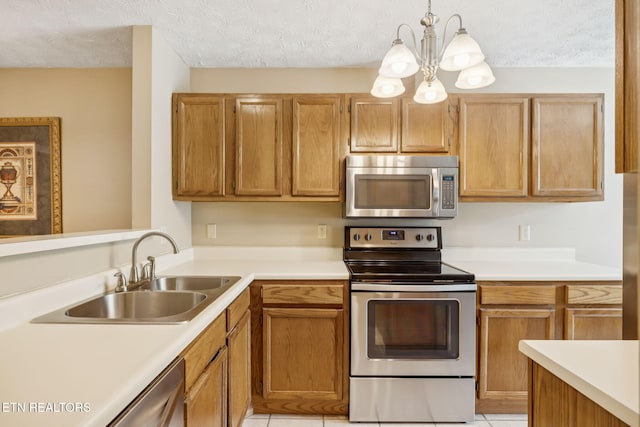 8600 Olde Colony Trl Unit 106, Knoxville, TN 37923 - kitchen featuring appliances with stainless steel finishes, light countertops, a chandelier, a textured ceiling, and hanging light fixtures