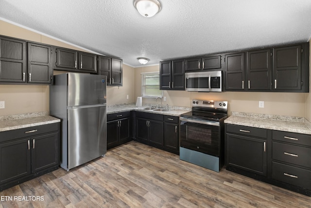 130 Hidden Estates Way, Newport, TN 37821 - kitchen featuring stainless steel appliances, a textured ceiling, light countertops, light wood-style flooring, and lofted ceiling