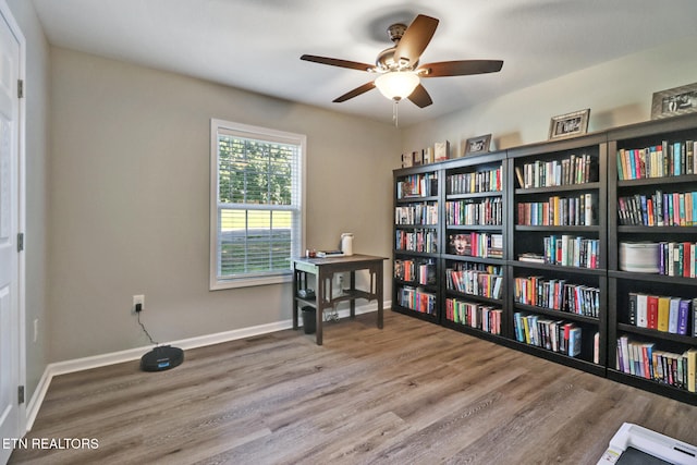 2296 Memory Garden Rd, Jamestown, TN 38556 - office area with wood finished floors, a ceiling fan, and wall of books