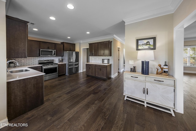 107 Cedarberry St, Oak Ridge, TN 37830 - kitchen featuring appliances with stainless steel finishes, dark brown cabinets, ornamental molding, backsplash, and light countertops