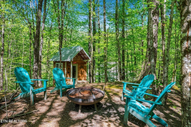 3721 Clabo Mountain Ln, Sevierville, TN 37862 - view of patio with a fire pit, an outbuilding, and a forest view