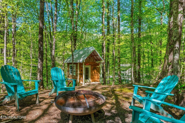 3721 Clabo Mountain Ln, Sevierville, TN 37862 - view of patio featuring a fire pit, an outbuilding, and a wooded view