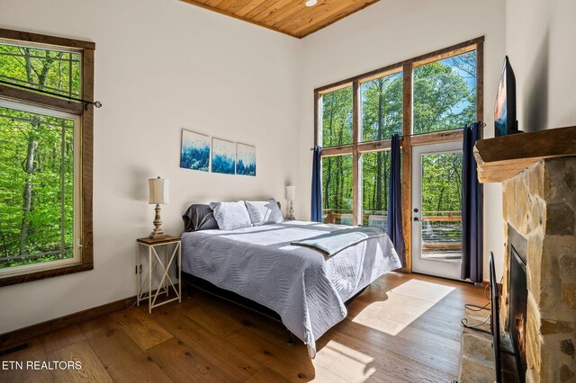 3721 Clabo Mountain Ln, Sevierville, TN 37862 - bedroom with access to exterior, wood finished floors, wooden ceiling, and a stone fireplace