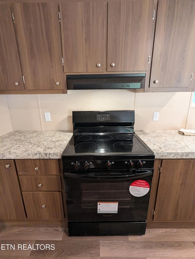 1431 Blue Springs Way, Newport, TN 37821 - kitchen with black range with electric stovetop, extractor fan, light countertops, and light wood-style flooring