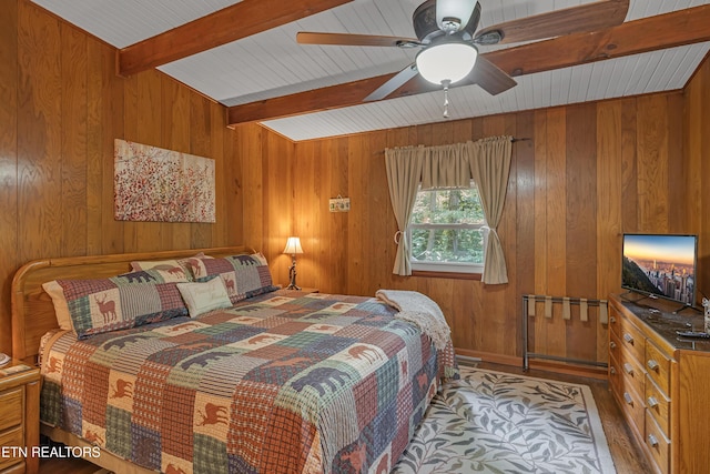 432 W Loop Rd, Gatlinburg, TN 37738 - bedroom featuring wood walls, beamed ceiling, wood finished floors, and a ceiling fan