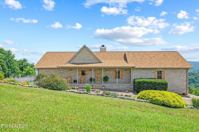 61 Brim Ln, Hilham, TN 38568 - view of front of home with covered porch, a front lawn, a chimney, and brick siding