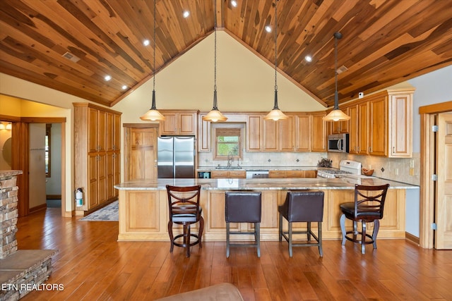 61 Brim Ln, Hilham, TN 38568 - kitchen featuring appliances with stainless steel finishes, a spacious island, light stone counters, hardwood / wood-style floors, and high vaulted ceiling