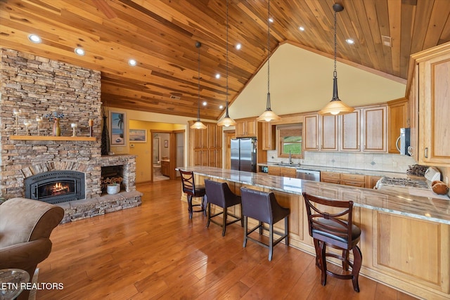 61 Brim Ln, Hilham, TN 38568 - kitchen featuring appliances with stainless steel finishes, wood ceiling, open floor plan, light stone countertops, and a kitchen bar