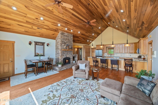 61 Brim Ln, Hilham, TN 38568 - living room featuring ceiling fan, light wood-style flooring, wood ceiling, a stone fireplace, and high vaulted ceiling