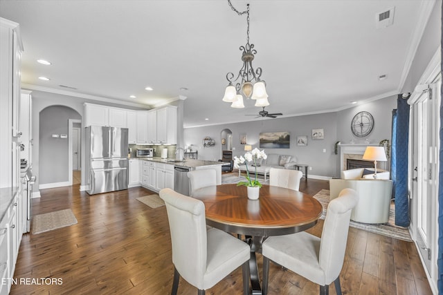 404 Chota Landing Way, Loudon, TN 37774 - dining area featuring arched walkways, a high end fireplace, crown molding, recessed lighting, and a chandelier