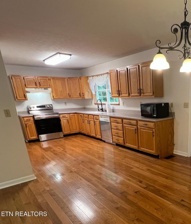 295 Clear Branch Rd, Corryton, TN 37721 - kitchen with stainless steel electric stove, black microwave, under cabinet range hood, dishwasher, and wood finished floors