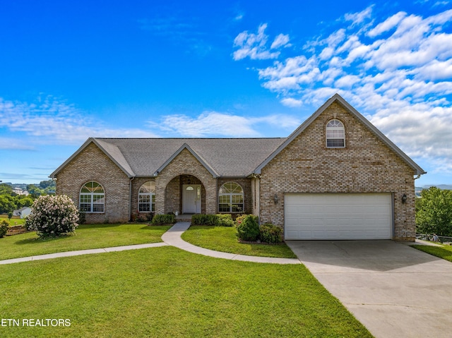 108 Skyline Dr, Dandridge, TN 37725 - view of front of home with a front yard, brick siding, driveway, and a garage