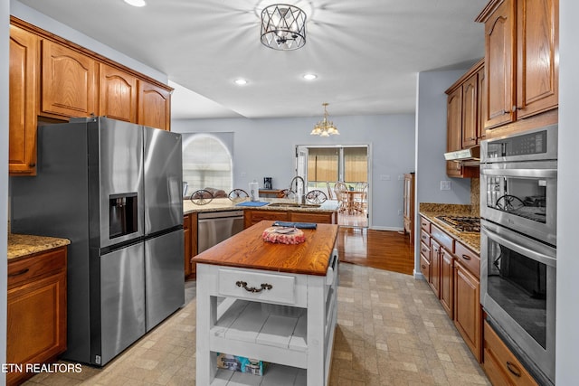 108 Skyline Dr, Dandridge, TN 37725 - kitchen with stainless steel appliances, a peninsula, a chandelier, recessed lighting, and light stone countertops