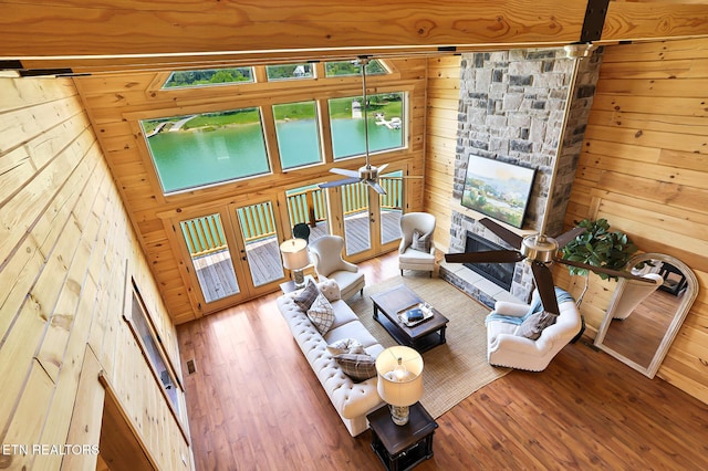 1144 Sanctuary Shores Way, Sevierville, TN 37876 - living room with wood walls, wood finished floors, a ceiling fan, a stone fireplace, and a barn door