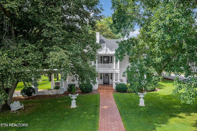 105 N Church St, Sparta, TN 38583 - obstructed view of property featuring covered porch, a front lawn, a chimney, and a balcony
