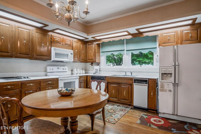 105 N Church St, Sparta, TN 38583 - kitchen featuring white appliances, light wood-style flooring, ornamental molding, light countertops, and a chandelier