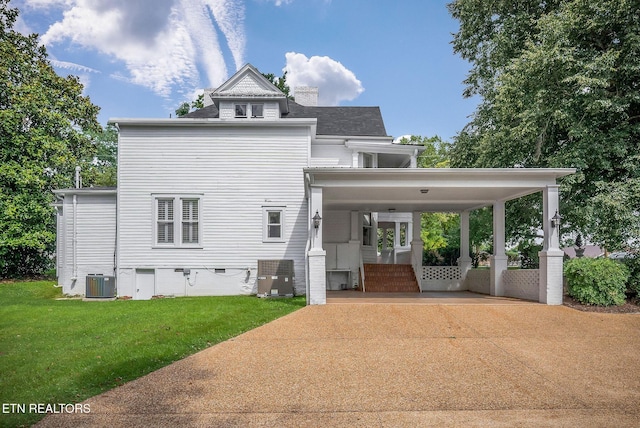 105 N Church St, Sparta, TN 38583 - back of property featuring driveway, a lawn, a carport, crawl space, and a chimney